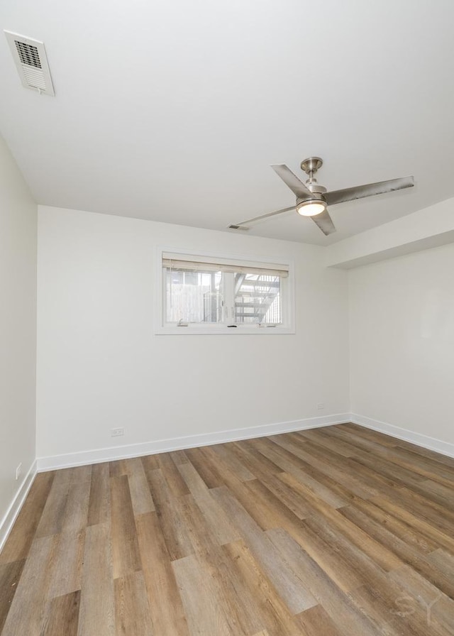 spare room with visible vents, baseboards, wood finished floors, and a ceiling fan