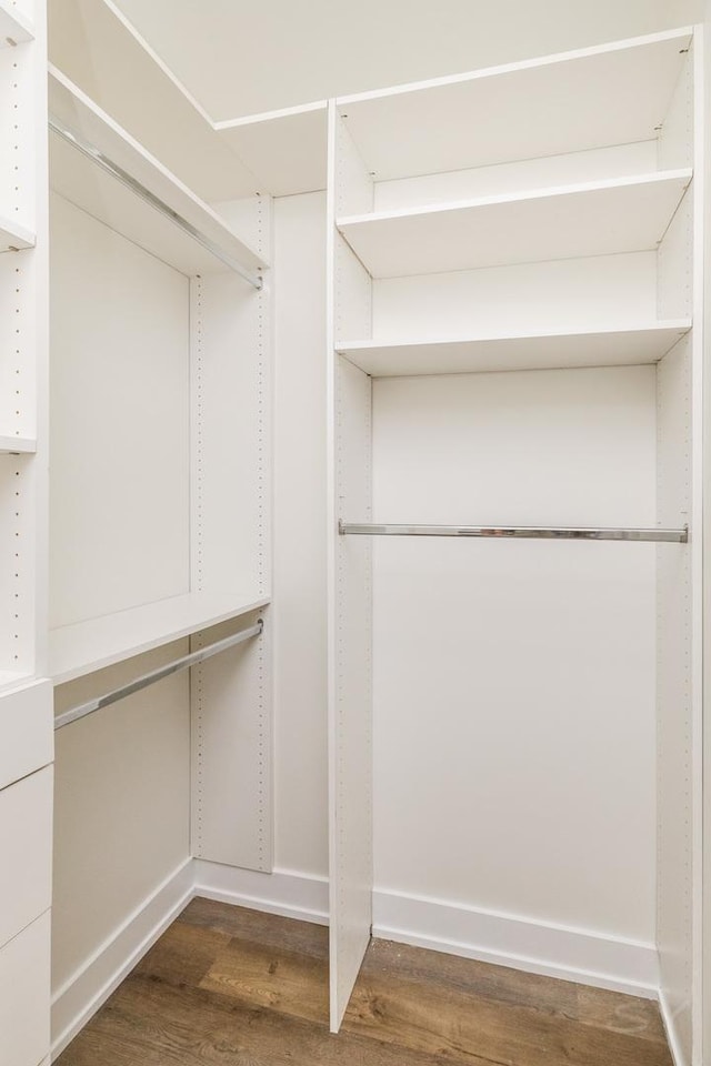 walk in closet with wood finished floors