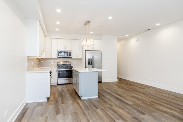 kitchen with backsplash, a center island, light countertops, stainless steel appliances, and a sink