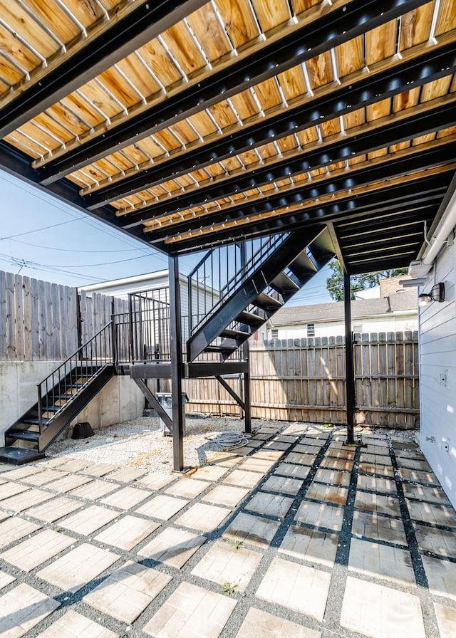 view of patio / terrace featuring stairway and fence