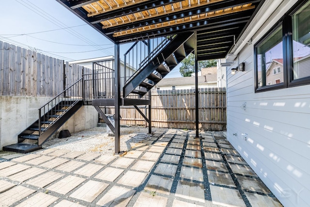 view of patio / terrace featuring stairway and fence