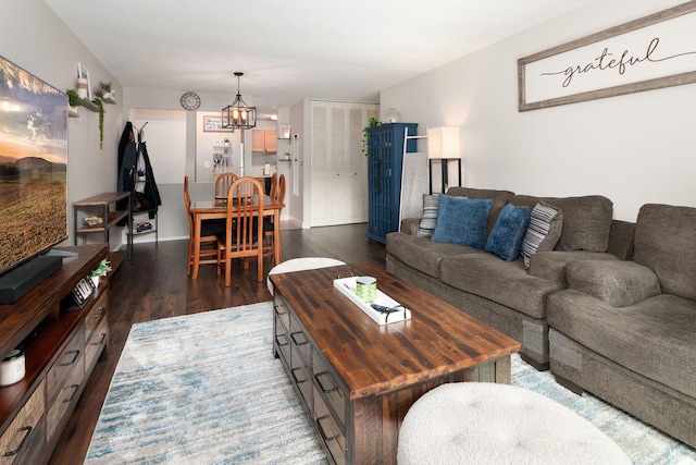 living area featuring a chandelier and dark wood finished floors