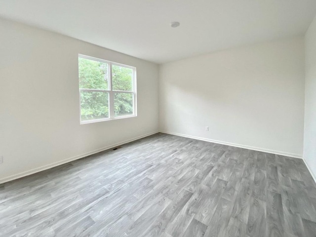 spare room featuring wood finished floors and baseboards