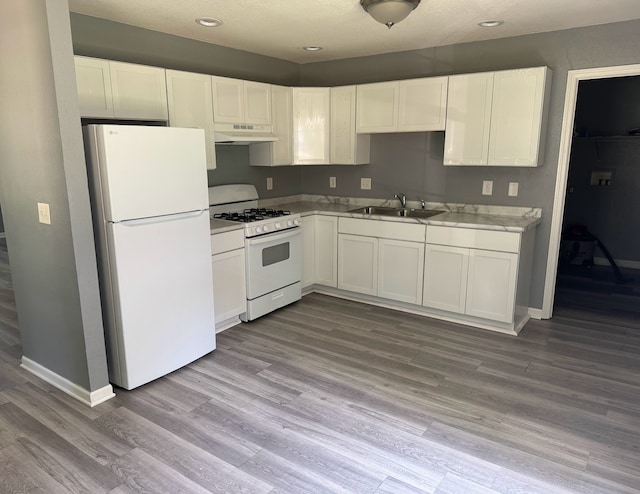 1312 N Hickory St, Champaign, IL 61820 - kitchen featuring white appliances, under cabinet range hood, white cabinetry, wood finished floors, and light countertops