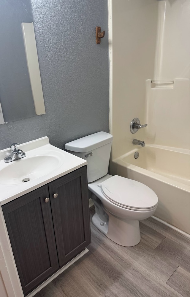 1312 N Hickory St, Champaign, IL 61820 - bathroom with wood finished floors, vanity, shower / bathtub combination, and a textured wall