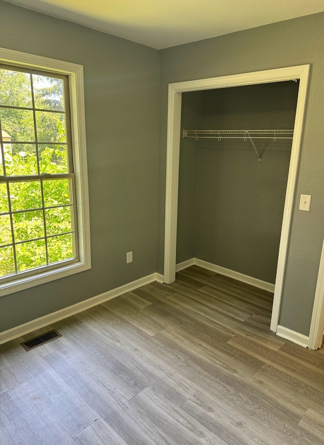 1312 N Hickory St, Champaign, IL 61820 - unfurnished bedroom with wood finished floors and a closet