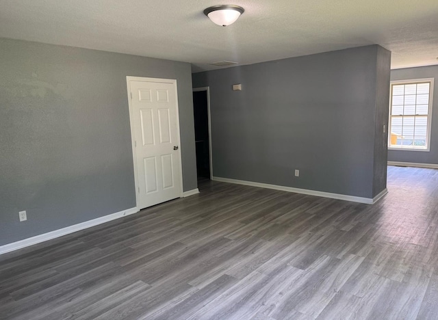 1312 N Hickory St, Champaign, IL 61820 - empty room with dark wood finished floors and a textured ceiling