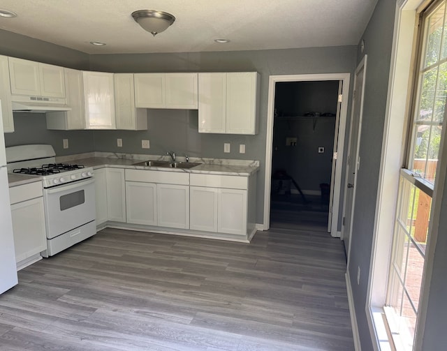 1312 N Hickory St, Champaign, IL 61820 - kitchen with gas range gas stove, under cabinet range hood, white cabinets, light countertops, and recessed lighting