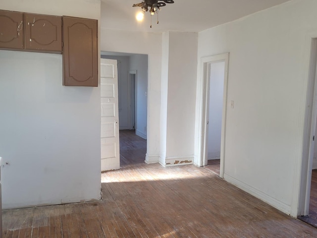 spare room featuring hardwood / wood-style flooring, a ceiling fan, and baseboards