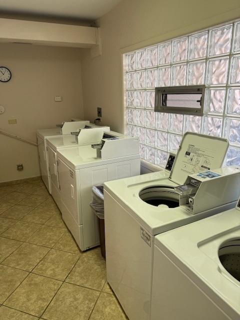 shared laundry area featuring light tile patterned floors and separate washer and dryer