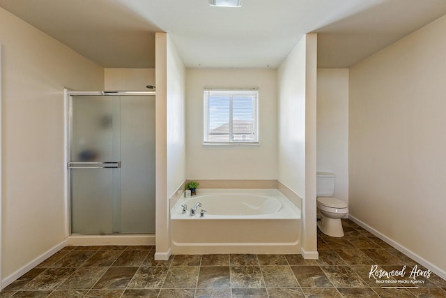 bathroom featuring toilet, a bath, a stall shower, and baseboards