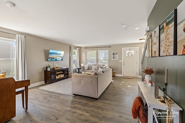 living area with dark wood-type flooring and baseboards