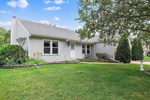 single story home featuring roof with shingles, a chimney, and a front yard