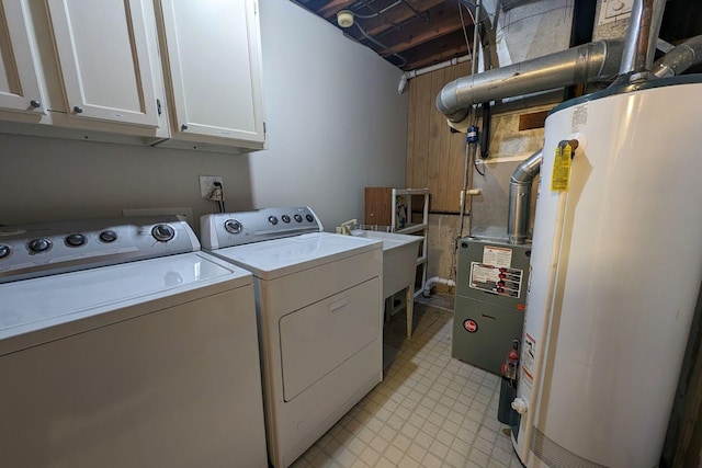 washroom featuring a sink, gas water heater, cabinet space, and washer and clothes dryer