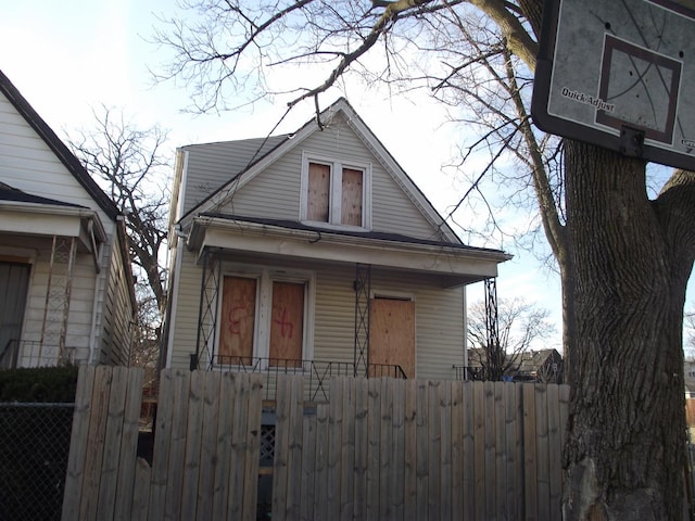 bungalow featuring a fenced front yard, covered porch, and a gate