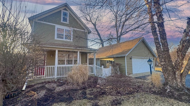 view of front facade with a detached garage and a porch