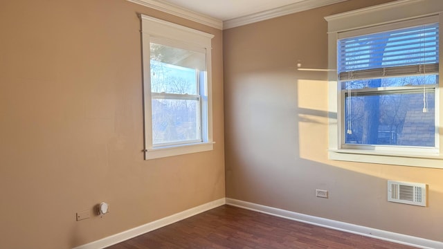 empty room with visible vents, baseboards, dark wood finished floors, and crown molding