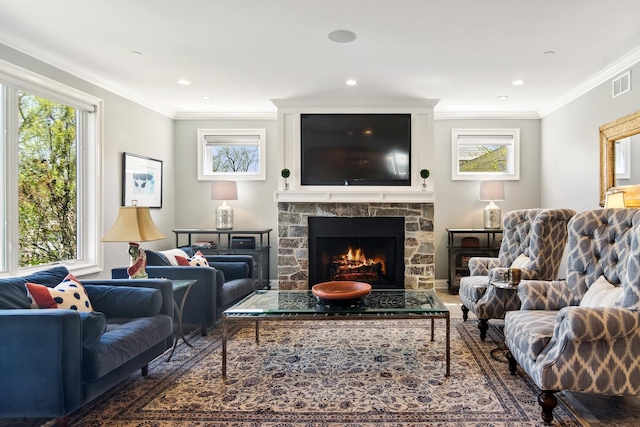 living area featuring visible vents, recessed lighting, a stone fireplace, and crown molding