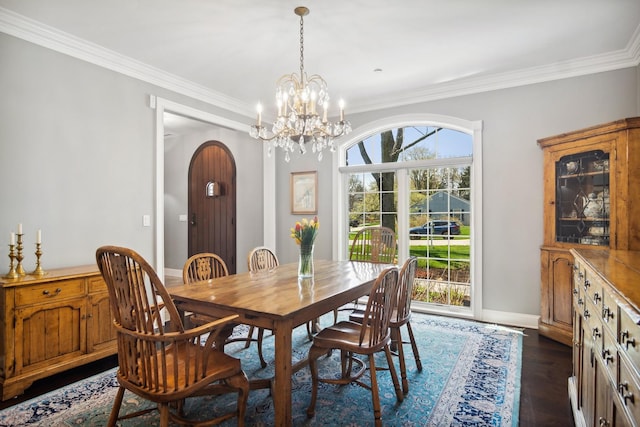 dining space with crown molding, a healthy amount of sunlight, and arched walkways