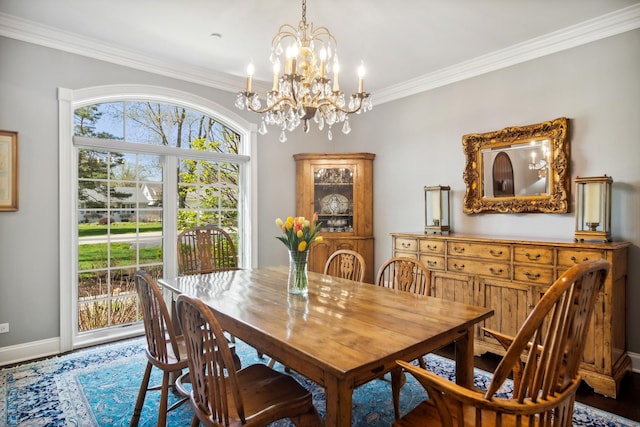 dining area featuring an inviting chandelier, baseboards, and ornamental molding