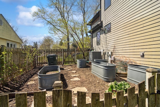 view of yard featuring central air condition unit and a fenced backyard