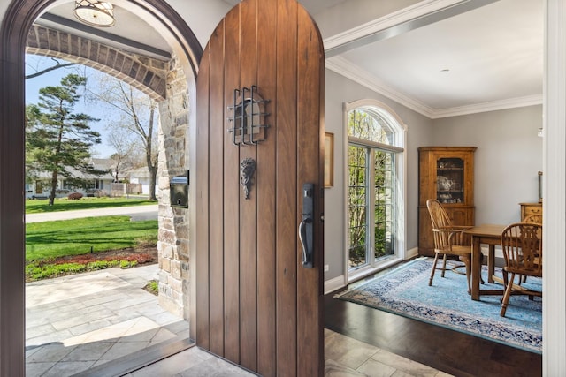 entryway featuring baseboards, wood finished floors, and crown molding