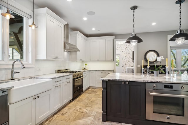 kitchen featuring tasteful backsplash, white cabinets, appliances with stainless steel finishes, and a sink