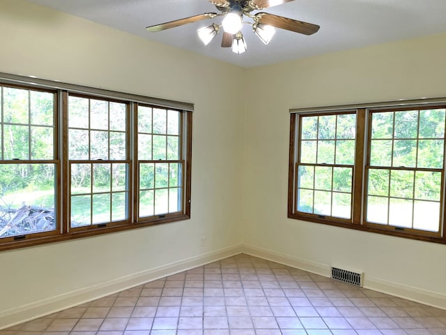 spare room with light tile patterned flooring, baseboards, visible vents, and ceiling fan