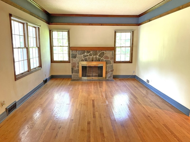 unfurnished living room with plenty of natural light, a fireplace, and crown molding