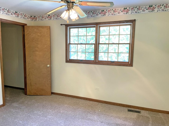 unfurnished room featuring carpet flooring, baseboards, visible vents, and ceiling fan