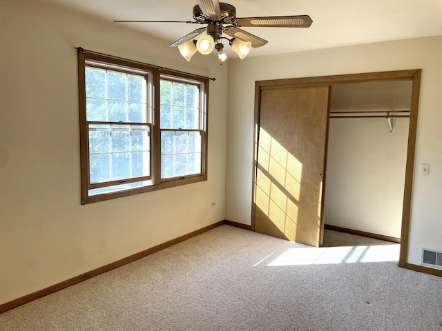 unfurnished bedroom with a ceiling fan, baseboards, visible vents, carpet floors, and a closet