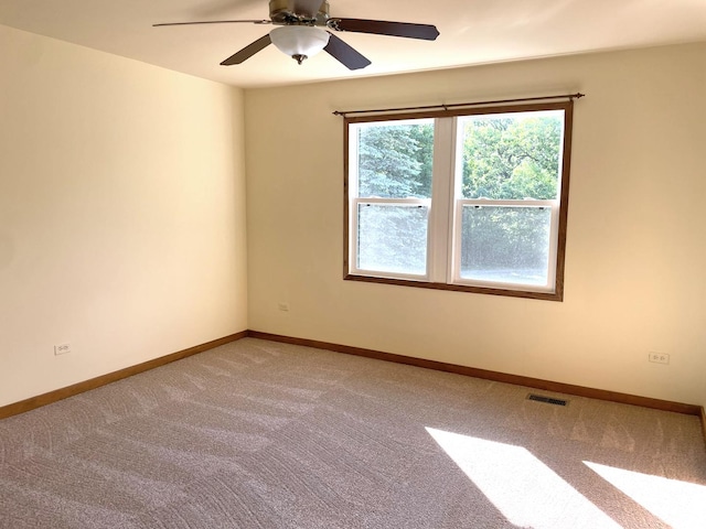 empty room with light carpet, visible vents, ceiling fan, and baseboards