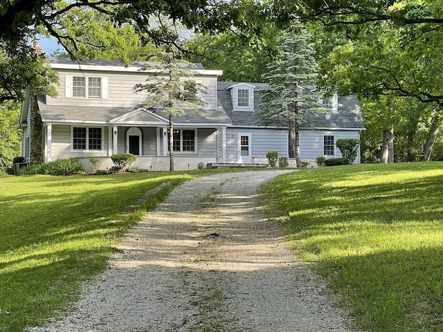 view of front of home featuring a front lawn, covered porch, and driveway