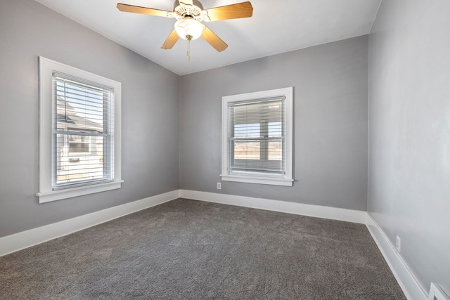 spare room featuring visible vents, baseboards, ceiling fan, and dark carpet