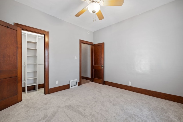 unfurnished bedroom with visible vents, a closet, carpet flooring, baseboards, and a spacious closet