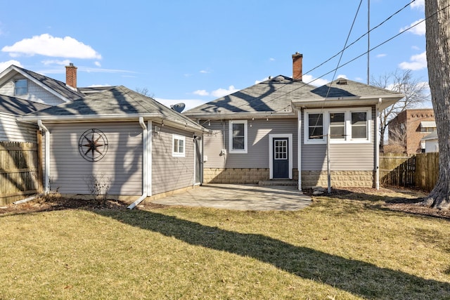 rear view of property with a patio, fence, a yard, a shingled roof, and a chimney