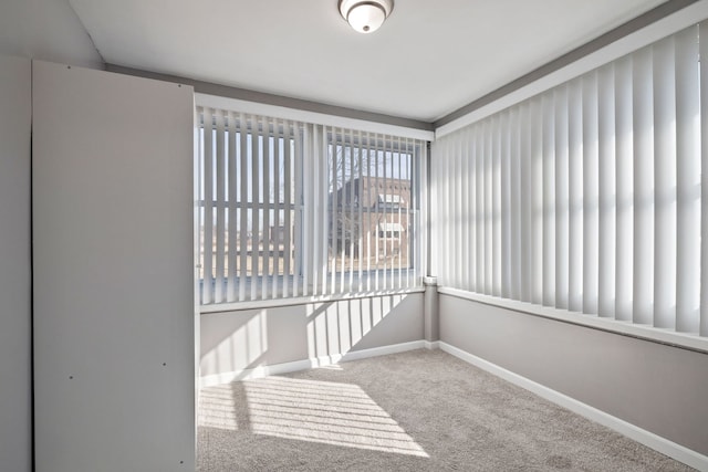 spare room featuring carpet flooring and baseboards