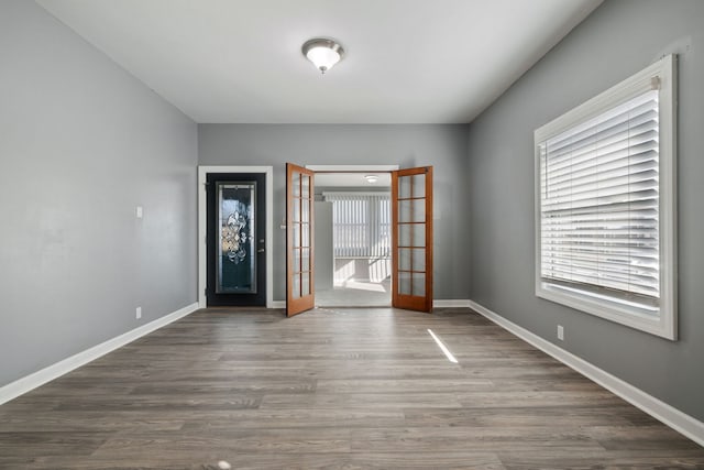 interior space with french doors, baseboards, and wood finished floors