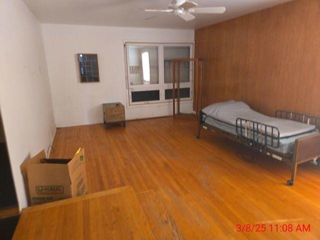 bedroom with wood finished floors and wood walls