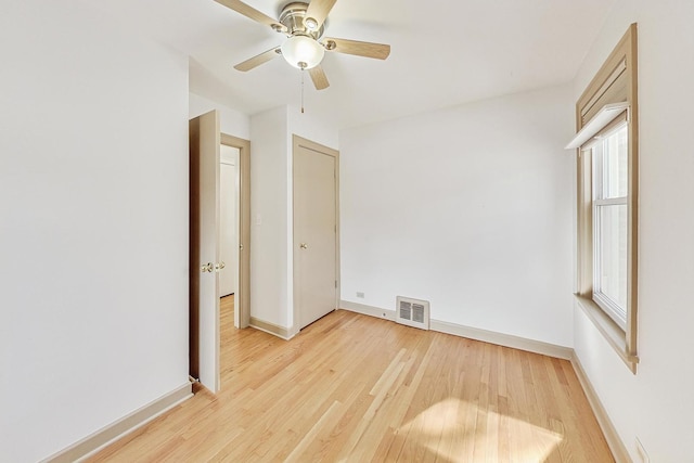 unfurnished bedroom featuring baseboards, visible vents, light wood finished floors, and ceiling fan