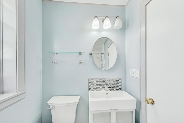 bathroom with decorative backsplash, toilet, and a sink