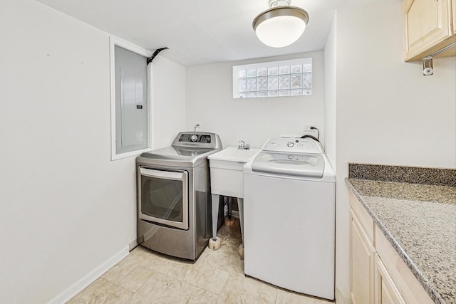 clothes washing area with electric panel, independent washer and dryer, cabinet space, and baseboards