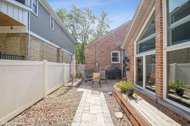 view of patio featuring a fenced backyard and a grill