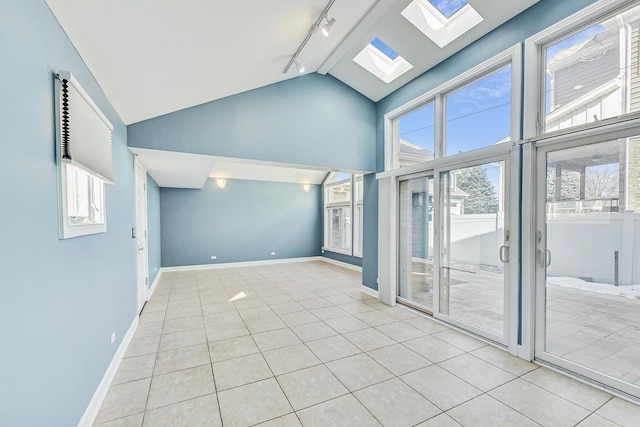 spare room with baseboards, a wealth of natural light, and high vaulted ceiling