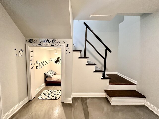 stairway featuring wood finished floors and baseboards