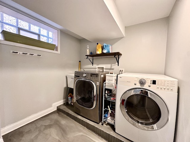 laundry area with laundry area, washing machine and dryer, and baseboards