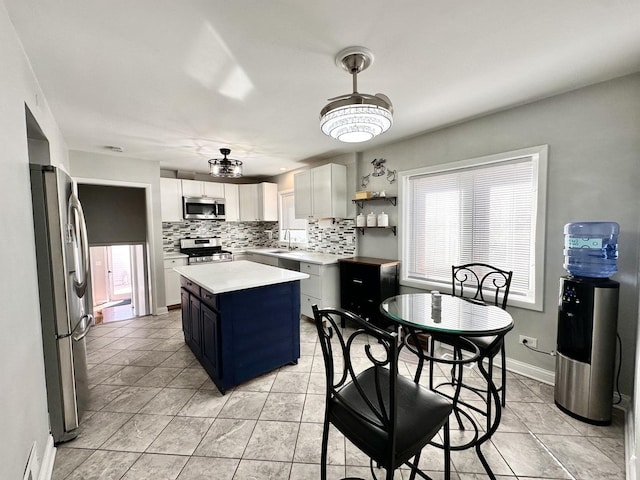 kitchen with a wealth of natural light, backsplash, stainless steel appliances, and light countertops