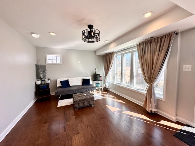 living area featuring a wealth of natural light, baseboards, and wood finished floors