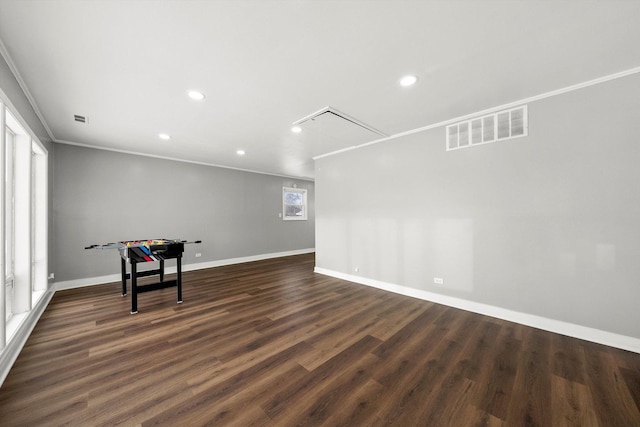 unfurnished room featuring baseboards, visible vents, dark wood-style flooring, and ornamental molding