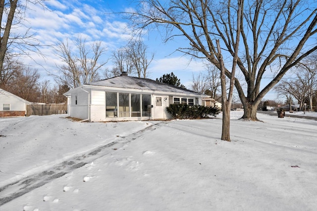 snow covered rear of property with brick siding